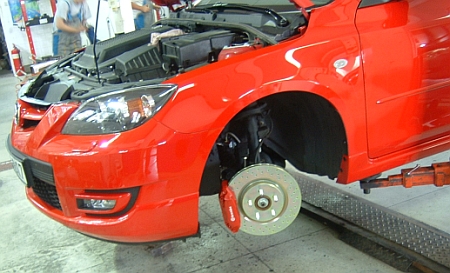 Immár a Mazda3 MPS-en a gyárinál 1 cm-rel nagyobb átmérőjű lyuggatott féktárcsa és a féknyereg