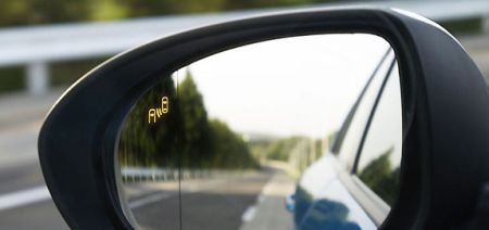 Az új Mazda3 térfigyelő rendszerének figyelmeztető jelzése a tükörben. Az új Mazda3 térfigyelő rendszerének figyelmeztető jelzése a tükörben.