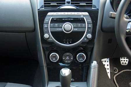 A középkonzol is változott, de a többi Mazda típussal ellentétben az RX-8 esetében továbbra is egy egység maradt az audio és a szellőzőrendszer.